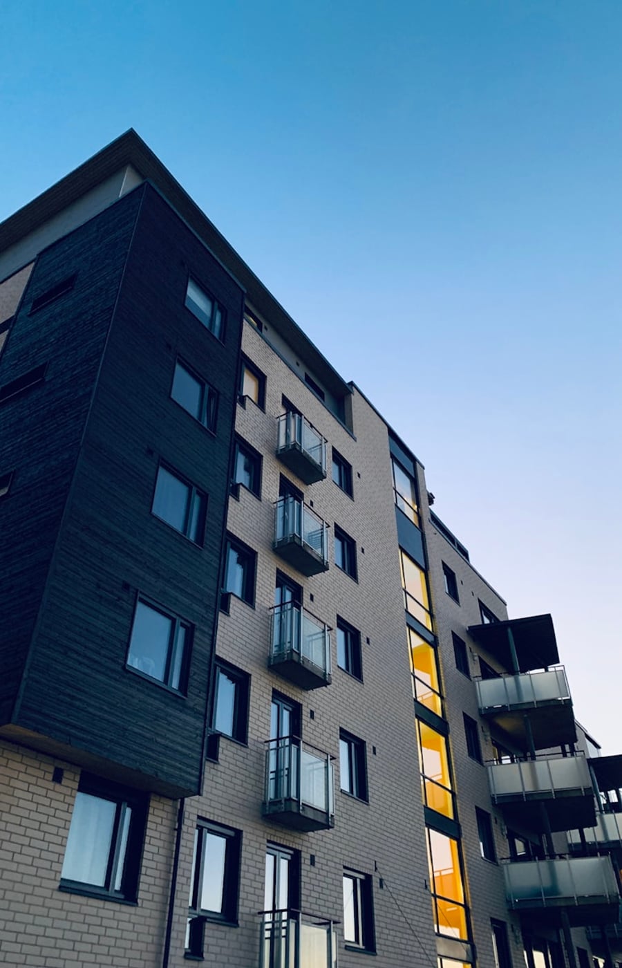 Tall view along a housing block corridor in late afternoon light.